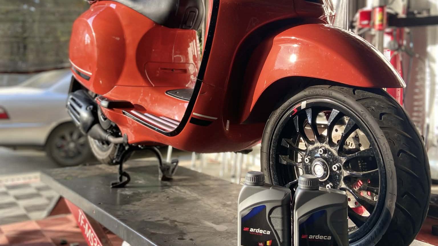 Vespa on the service lift with Ardeca synthetic oil at MotoNorte