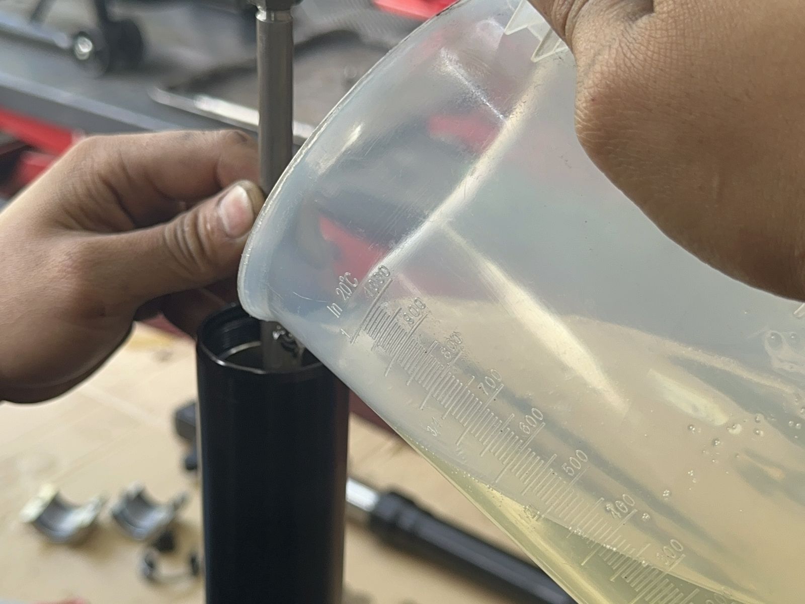 MotoNorte technician refilling fork oil during a suspension service in Batac